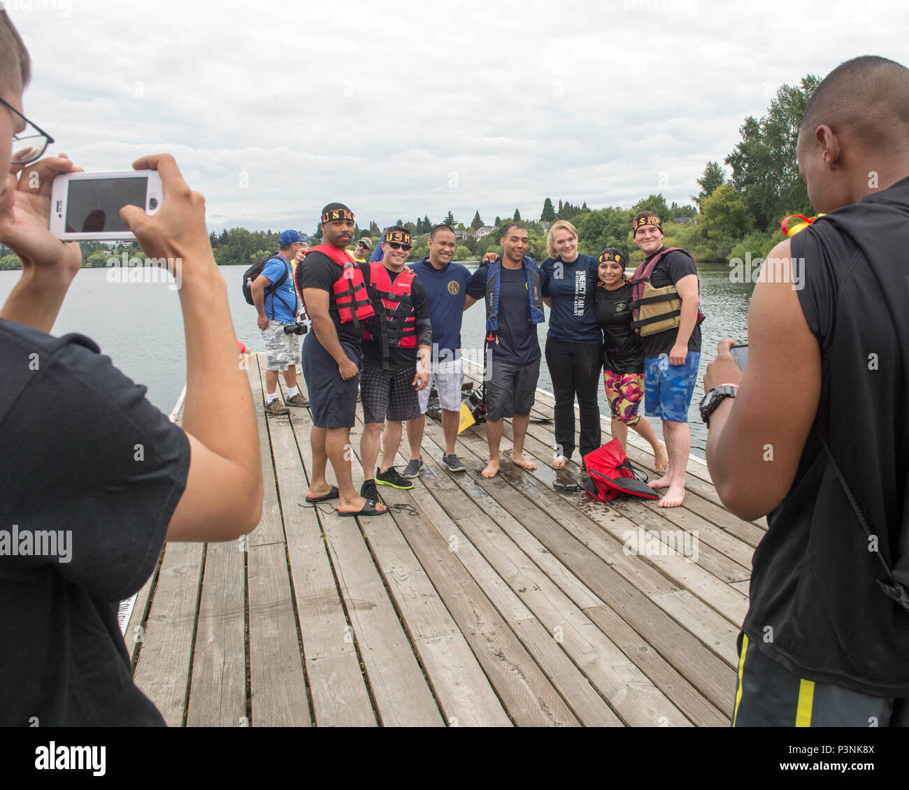 160716-N-LQ926-454 SEATTLE, Wash. (July 16, 2016) -- Sailors assigned to Navy Region Northwest and Marines from Combat Logistic Battalion 23, out of Joint Base Lewis-McCord pose for a group photo after the Albertsons/Safeway Seafair Milk Carton Derby military race held at the Green Lake Aqua Theater in Seattle. The event is part of the annual Seattle Seafair maritime summer celebration. (U.S. Navy photo by Mass Communication Specialist 2nd Class Alex Van’tLeven/Released) Stock Photo