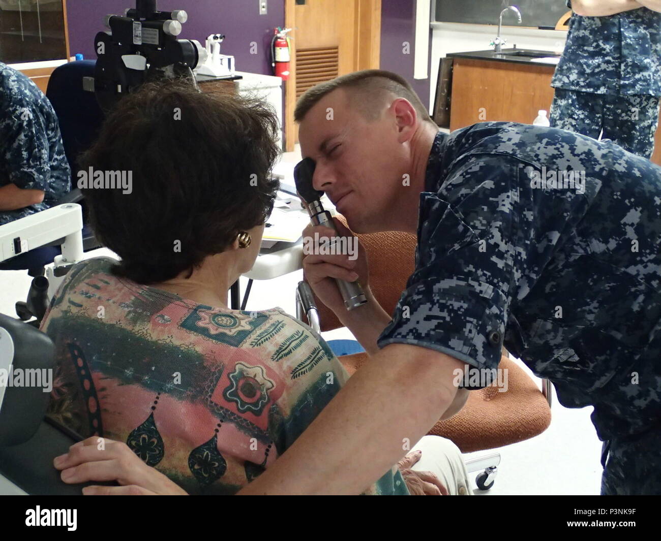 Lt. John Vingoe, an optometrist from the Naval Branch Health Clinic, Groton, Conn., conducts an eye exam on a patient during Greater Chenango Cares on July 15, 2016.  Greater Chenango Cares is one of the Innovative Readiness Training missions which provides real-world training in a joint civil-military environment while delivering world class medical care to the people of Chenango County, N.Y., from July 15-24. Stock Photo