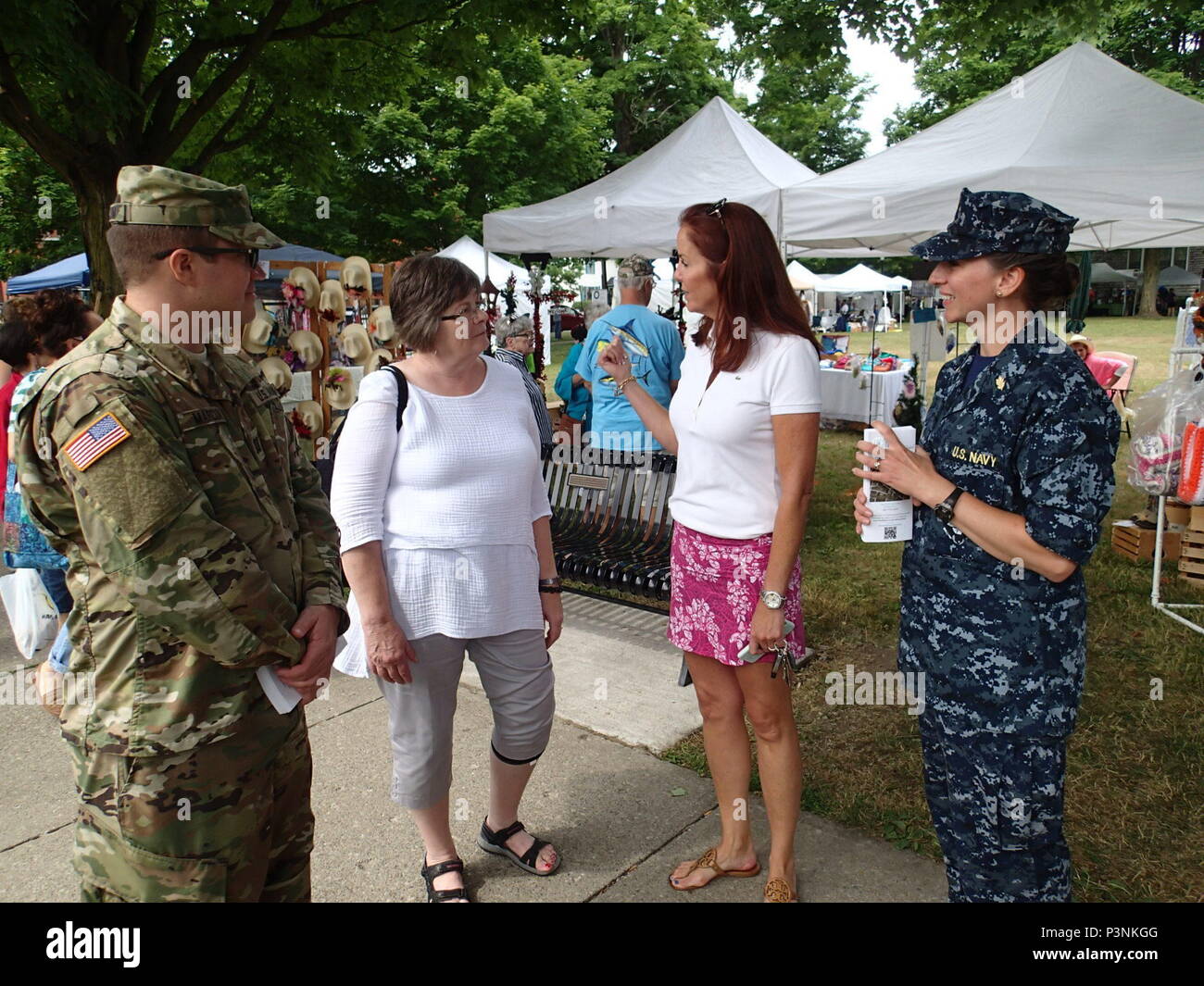 Army Capt. Lucas Marcum, a triage nurse from Company Bravo 48th Combat Support Hospital, and Navy Lt. Cmdr. Cathleen Bruni, a triage nurse from Expeditionary Medical Facility Bethesda speak with Homer Mayor Genevieve Suits and community members about the Healthy Cortland event July 16, 2016.  Healthy Cortland is one of the Innovative Readiness Training events which provides real-world training in a joint civil-military environment while delivering world-class medical care to the people of Cortland, N.Y., from July 15-24. Stock Photo