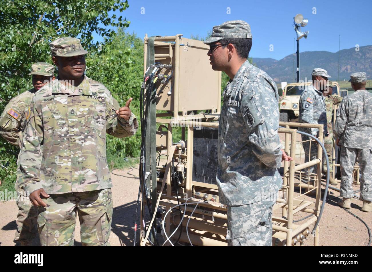 Spc. Angel Fani, right, 247th Composite Supply Company, 68th Combat Sustainment Support Battalion, 4th Sustainment Brigade, 4th Infantry Division, demonstrates a lightweight water purifier during the 4th Inf. Div. Water Expo July 7, 2016, at Haymes Reservoir. (Photo by Sgt. Benjamin Kullman) Stock Photo