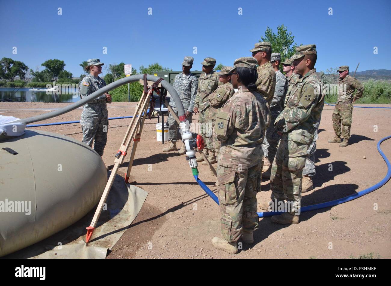 Pfc. Tiffany Hayden, left, 247th Composite Supply Company, 68th Combat Sustainment Support Battalion, 4th Sustainment Brigade, 4th Infantry Division, explains the functions of a tactical water purification system to Soldiers attending the 4th Inf. Div. Water Expo July 7, 2016, at Haymes Reservoir. (Photo by Sgt. Benjamin Kullman) Stock Photo