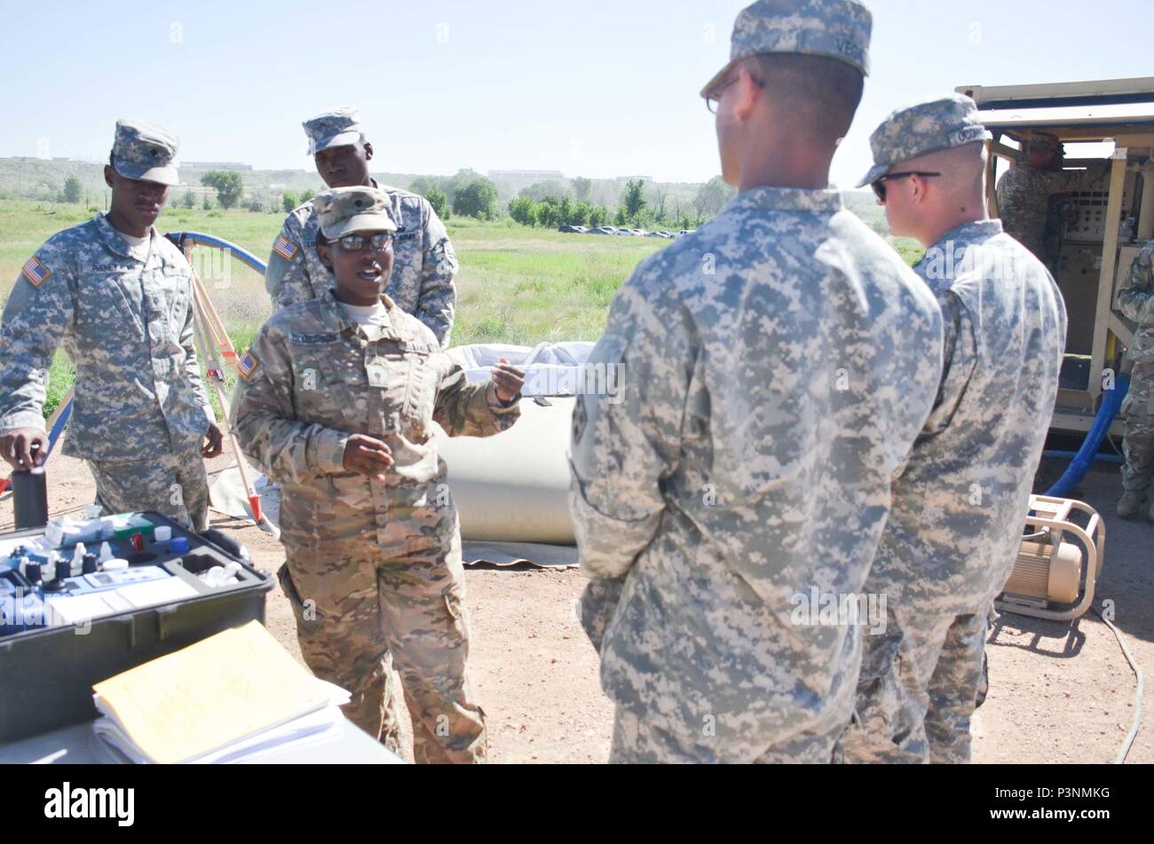 Spc. Shredia Tucker-Johnson, 247th CSC, 68th Combat Sustainment Support Battalion, 4th Sustainment Brigade, 4th Infantry Division (center) demonstrates the proper procedures for running a Water Quality Analysis Set- Purification (WQAS-P) during the 4th Infantry Division Water Expo July 7 at Haymes Reservoir. (U.S. Army photo by Sgt. Benjamin Kullman) Stock Photo