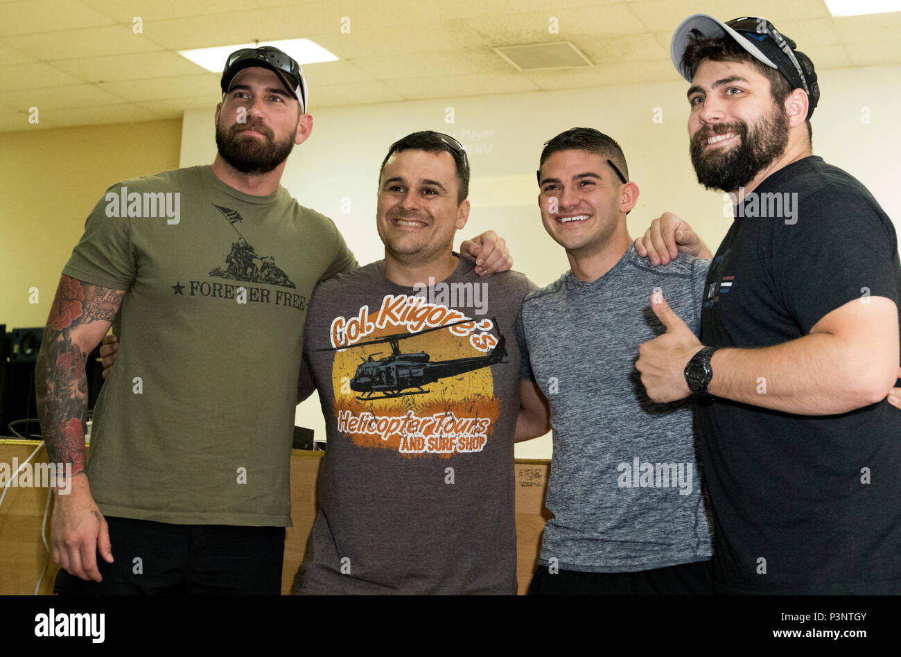 Range 15 actors and veterans Matt Best, left, Nick Palmisciano and Jarred  “J.T.” Taylor pose with a Soldier for a photograph July 14 at Camp Arifjan,  Kuwait. The three former service members