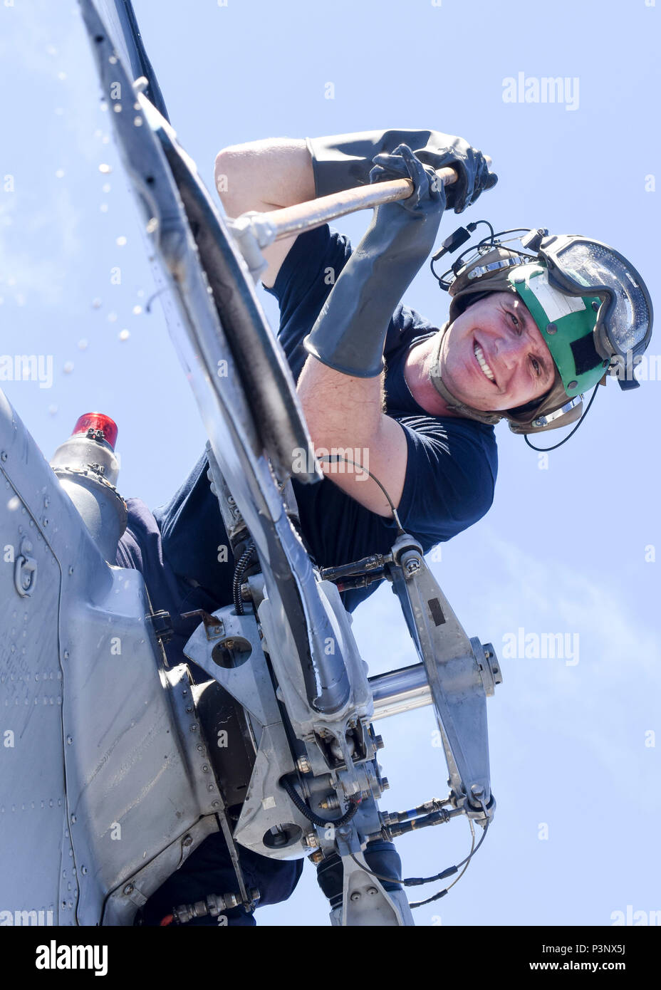 160713-N-LI612-437 PACIFIC OCEAN (July 13, 2016) Aviation Electronics Technician 2nd Class Trey Perry, of Windsor, California, assigned to Helicopter Maritime Strike Squadron (HSM) 35, “The Magicians”, washes the tail rotor of an MH-60R Sea Hawk helicopter on the flight deck of the Arleigh Burke-class Guided-missile destroyer USS Pinckney (DDG 91) in preparation for flight operations during RIMPAC. Arleigh Burke-class guided missile destroyer USS Pinckney (DDG 91). Twenty-six nations, more than 40 ships and submarines, more than 200 aircraft and 25,000 personnel are participating in RIMPAC fro Stock Photo