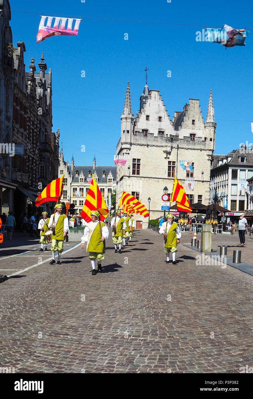 Mechelen, Belgium - May 2018: group of men carrying the red and yellow striped city flag of Mechelen during the Hanswijk procession on the Ijzerenleen Stock Photo