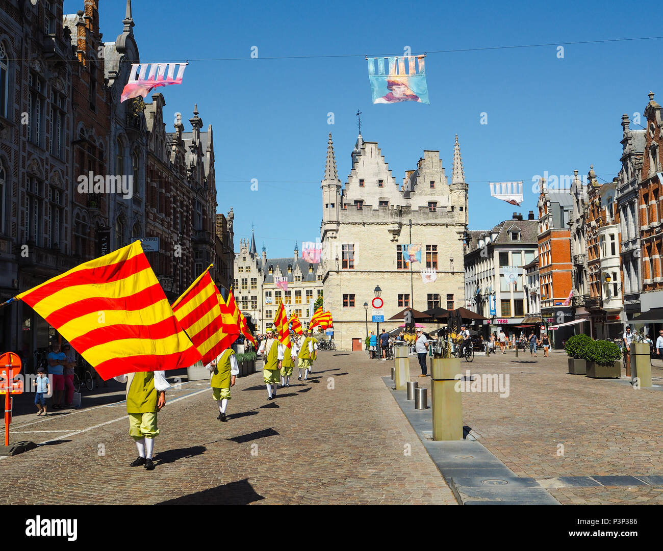 Mechelen, Belgium - May 2018: Men participating in the Hanswijk procession, carrying the city flag of Mechelen while walking on the Ijzerenleen Stock Photo