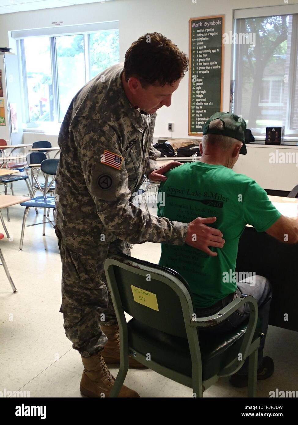 Lt. Col. Christopher James, a physician from Company A, 48th Combat Support Hospital out of Fort Story, Va., conducts a physical exam of a patient during Greater Chenango Cares, July 21, 2016.  Greater Chenango Cares is one of the Innovative Readiness Training events that provides real-world training in a joint civil-military environment while delivering world-class medical care to the people of Chenango County, N.Y., from July 15-24. Stock Photo