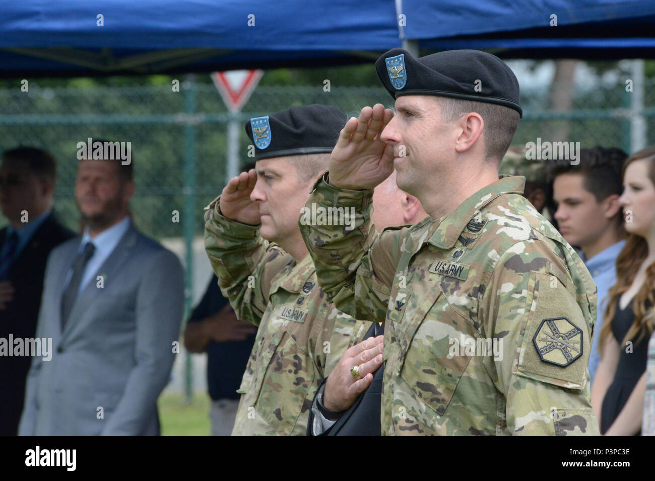 ANSBACH, Germany (July 21, 2016) – From right foreground, Col. Benjamin C. Jones, incoming commander of U.S. Army Garrison Ansbach; Michael D. Formica, Installation Management Command – Europe director; and Col. Christopher M. Benson, outgoing commander of USAG Ansbach, observe the entrance of the color guard onto the field. USAG Ansbach said farewell to commander Benson and welcomed commander Jones during a ceremony Monday on the Barton Barracks athletic field here. Stock Photo