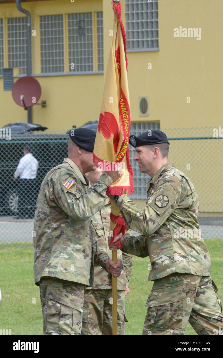 ANSBACH, Germany (July 21, 2016) – Col. Benjamin C. Jones, right, the new commander of U.S. Army Garrison Ansbach, passes the garrison guidon to Command Sgt. Maj. Derek R. Cuvellier during the USAG Ansbach change of command ceremony. U.S. Army Garrison Ansbach said farewell to commander Col. Christopher M. Benson and welcomed commander Jones during a ceremony Monday on the Barton Barracks athletic field here. Stock Photo
