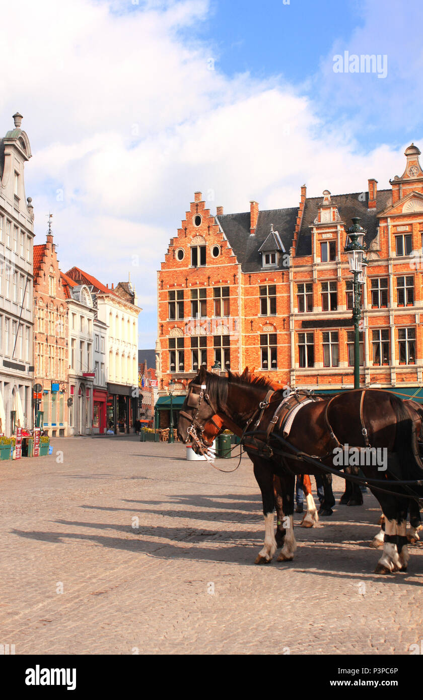 Old houses and horse carriages on Grote Markt square, medieval city Brugge, Belgium, Europe. UNESCO world heritage site Stock Photo