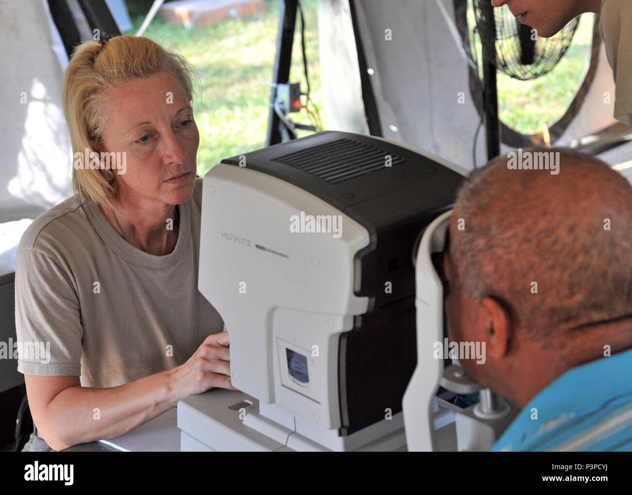 U.S. Army Sgt. Angelia Matheis, an Army Reserve eye specialist assigned to the Wyoming National Guard Medical Detachment during Beyond the Horizon 2017, uses an auto refractormeter while testing how a patient's eyes focus on the first day of a medical readiness event being held from May 8-16 in San Ignacio, Belize. BTH 2017 is a U.S. Southern Command-sponsored, Army South-led exercise designed to provide humanitarian and engineering services to communities in need, demonstrating U.S. support for Belize. Stock Photo