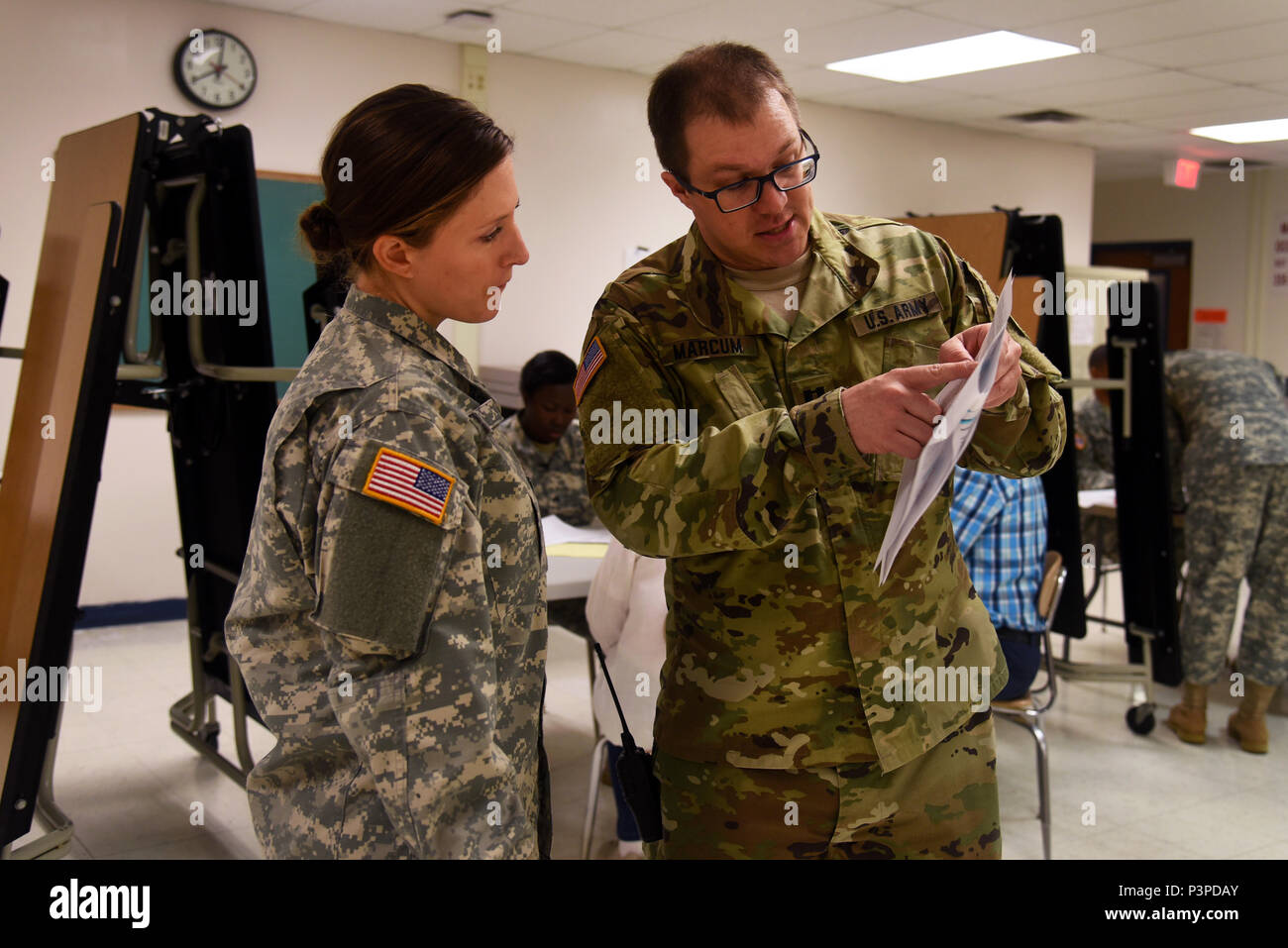 U.S. Army 1st Lt. Christine Barr, 48th Combat Support Hospital, listens to Capt. Lucas Marcum as he explains the process of the preliminary health screenings during the Healthy Cortland event at Homer Intermediate School in Homer, N.Y., July 19, 2016. Service members provided no cost medical, dental, optometry, and veterinary care to local citizens. (U.S. Air National Guard photo by Senior Airman Julia Santiago) Stock Photo