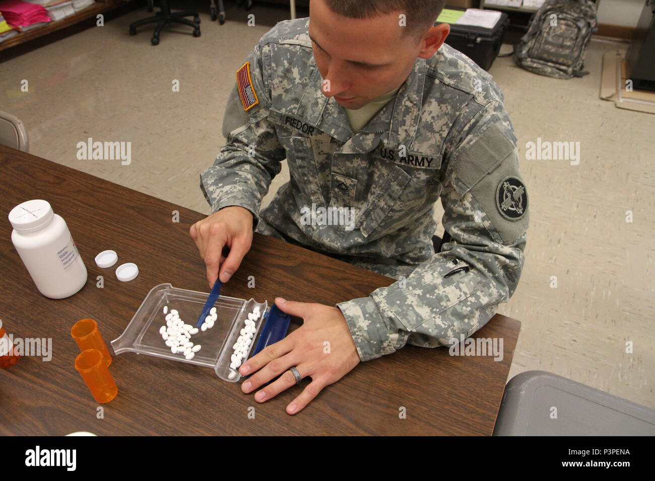 Pfc. Michael Fiedor, a pharmacy technician from Alpha Company, 48th Combat Support Hospital out of Fort Meade, Md., counts pills to fill a prescription during the Greater Chenango Cares Innovative Readiness Training event, July 20, 2016.  Greater Chenango Cares is one of the IRT events that provides real-world training in a joint civil-military environment while delivering world-class medical care to the people of Chenango County, N.Y., from July 15-24. Stock Photo