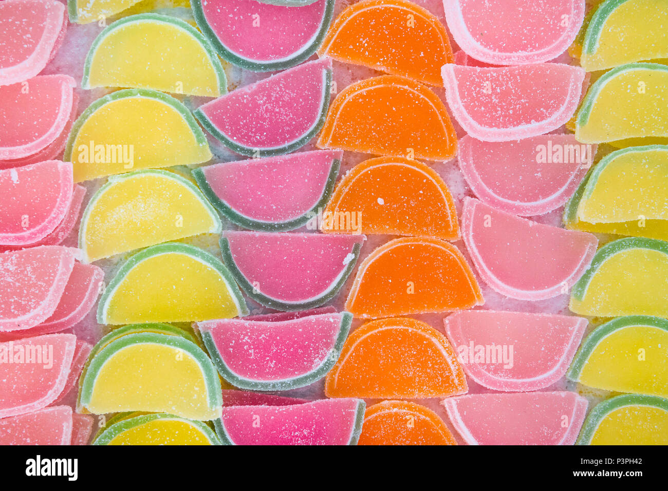 Jelly Marmalade Candies of Various Colors in Shape of Citrus Fruits Watermelon Wedges. Vivid Multicolored Palette Orange Yellow Green Red Pink. Patter Stock Photo