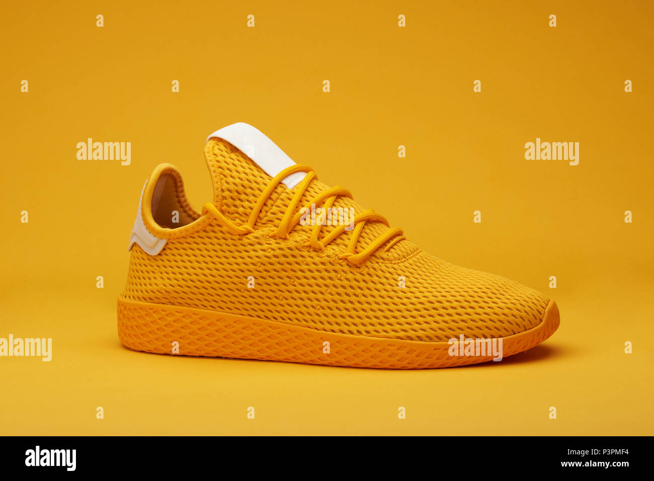 One yellow sport shoe isolated on orange background Stock Photo
