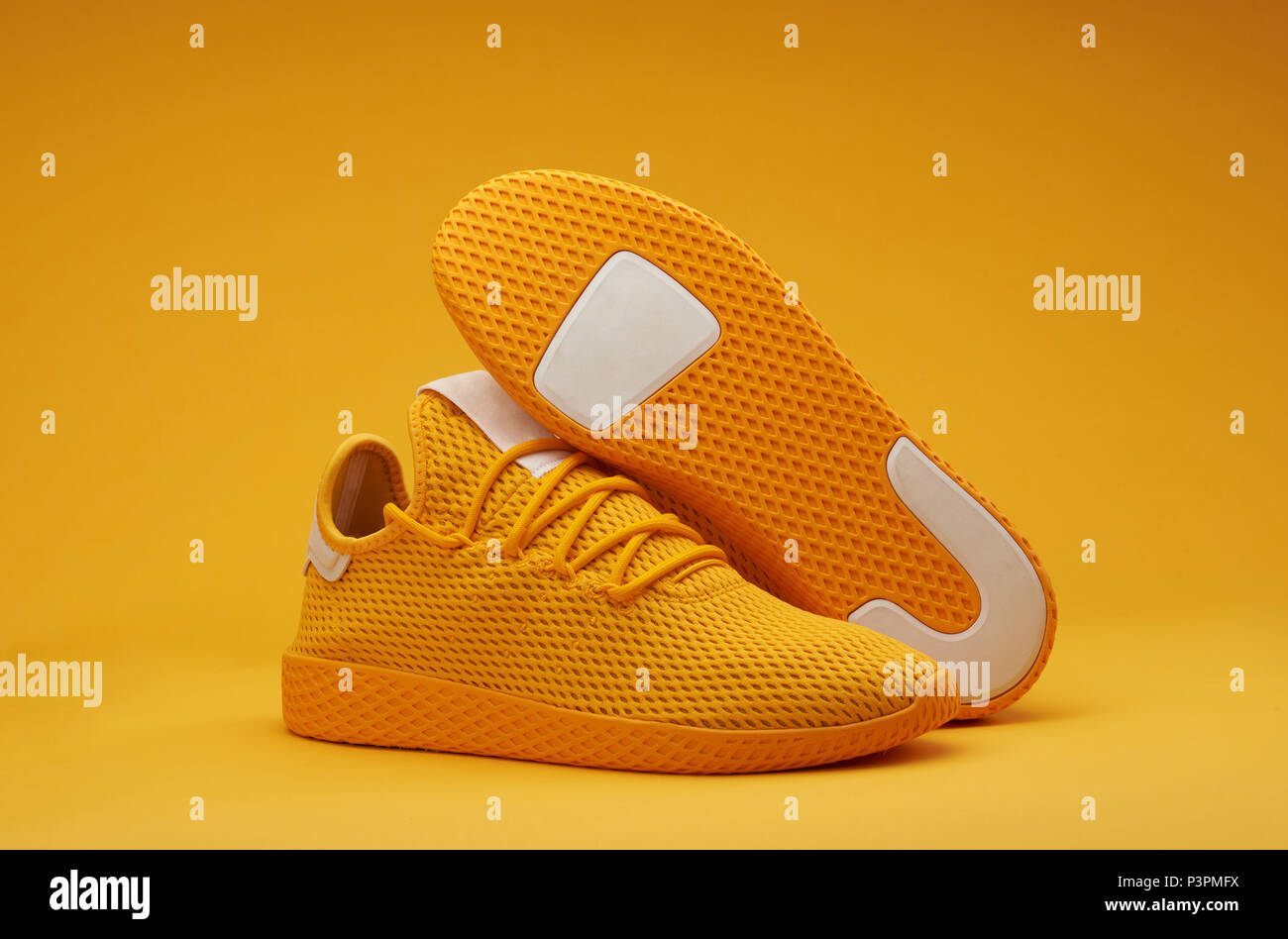 Sport shoes theme in yellow color. Pair of tennis shoes Stock Photo