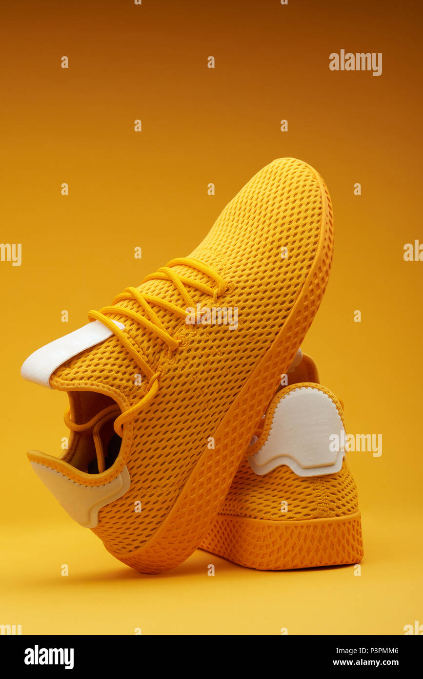 Pair of yellow sport shoes on orange background Stock Photo