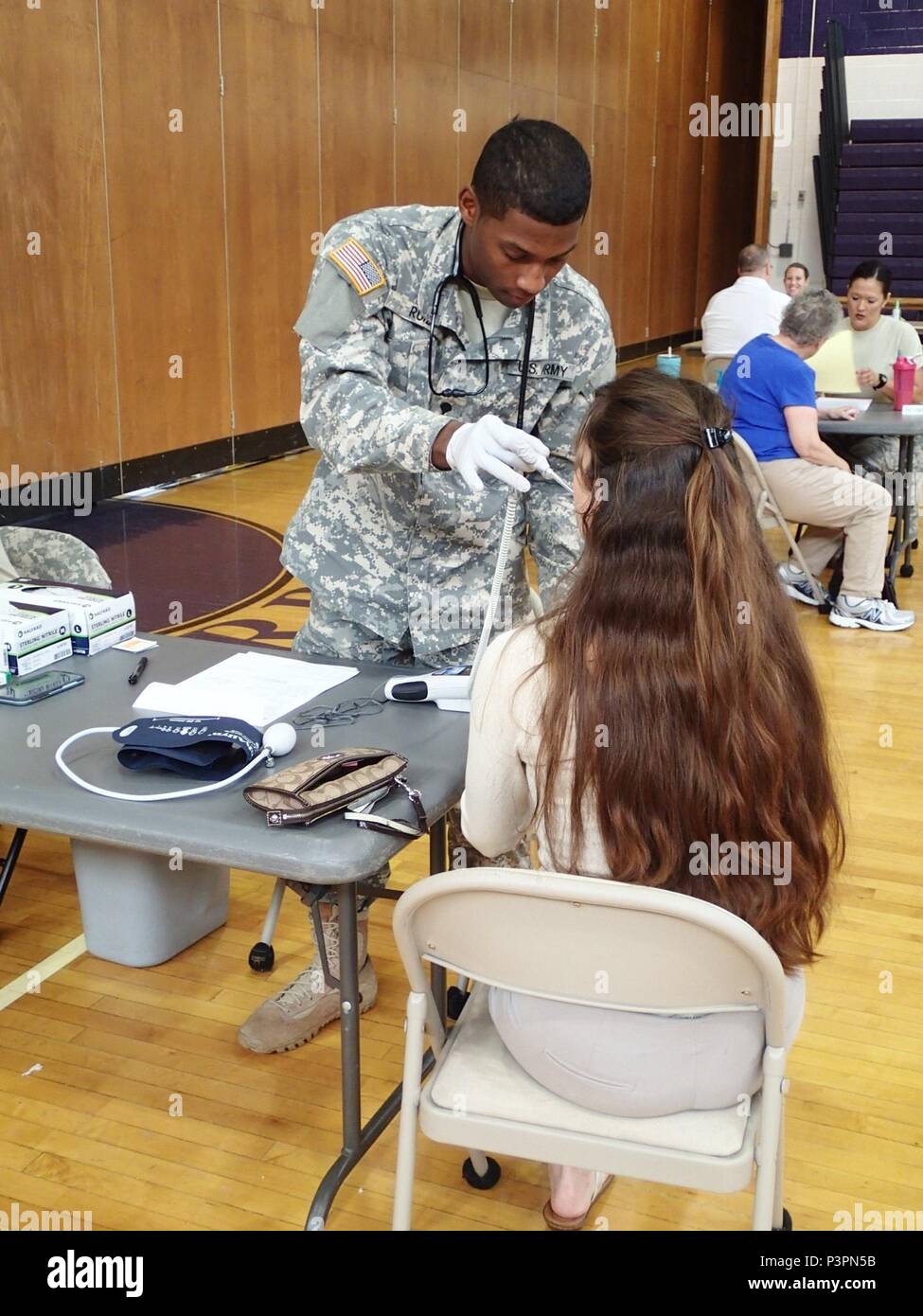 Spc. Xavier Ruiz, a licensed practical nurse from Company A, 48th Combat Support Hospital, Fort Story, Va., takes vital signs from a community member during the Greater Chenango Cares Innovative Readiness Training event, July 19, 2016.  Greater Chenango Cares is one of the Innovative Readiness Training events which provides real-world training in a joint civil-military environment while delivering world class medical care to the people of Chenango County, N.Y., from July 15-24. Stock Photo