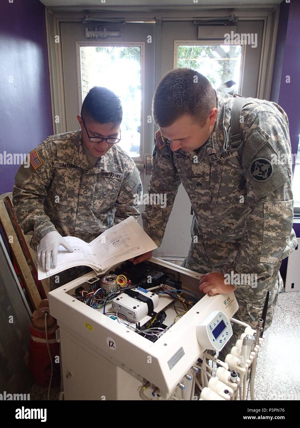 Sgt. Christopher Ramos, a biomedical technician from Company A, 48th Combat Support Hospital, Fort Story, Va., and Pfc. Albertico Saldana, a biomedical technician from the 341st Medical Logistics, Newtown Square, Pa. perform maintenance on a piece of dental equipment during Greater Chenango Cares, July 20, 2016.  Greater Chenango Cares is one of the Innovative Readiness Training events which provides real-world training in a joint civil-military environment while delivering world class, no-cost medical, dental, optometry and veterinary care to the people of Chenango County, N.Y., from July 15- Stock Photo