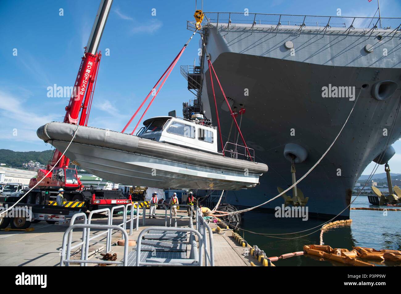 At Sasebo, Japan, Japanese contractors position an 11 meter rigid hull ...