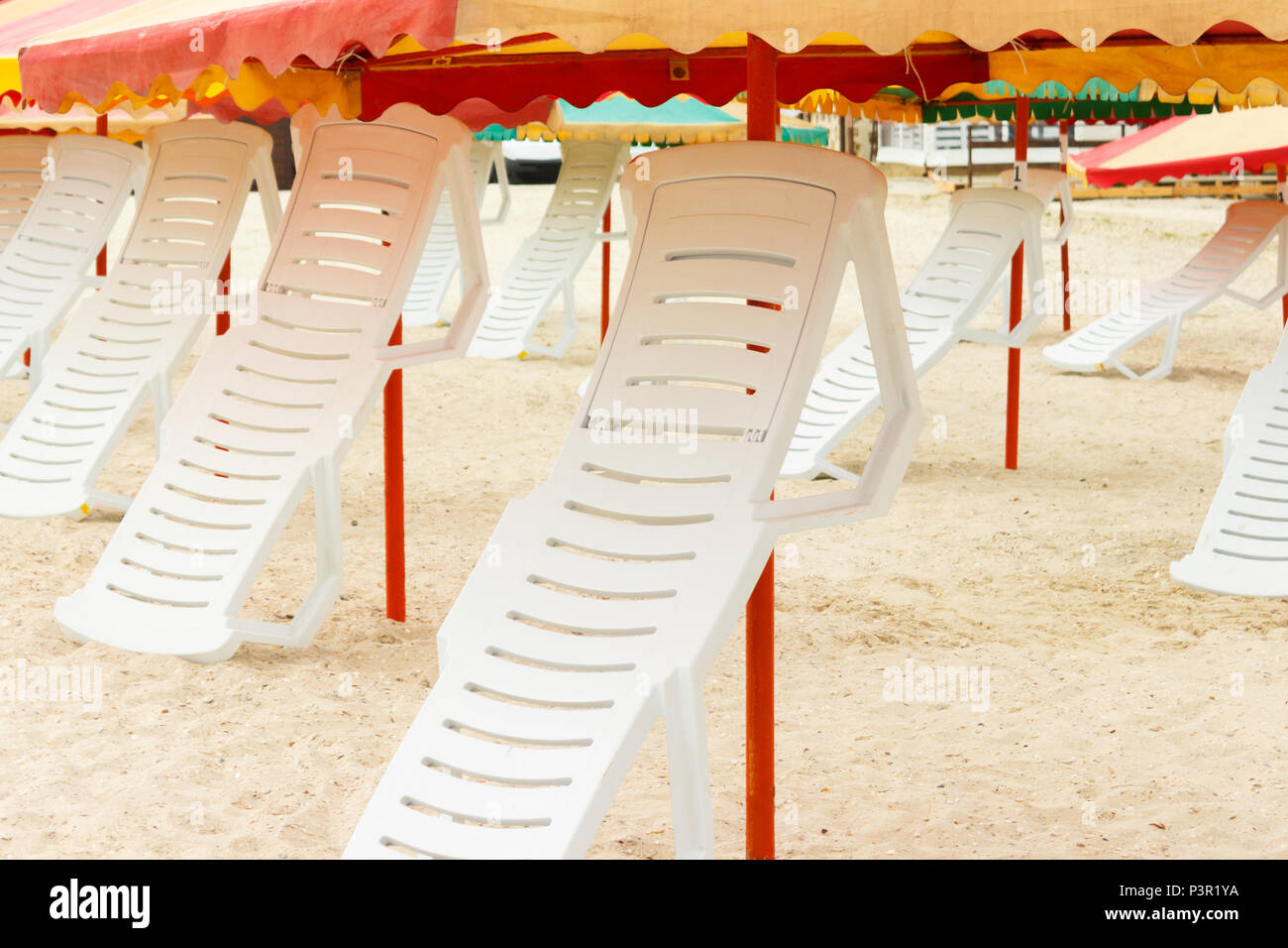 folded chaise lounges and umbrellas on the sandy beach Stock Photo Alamy