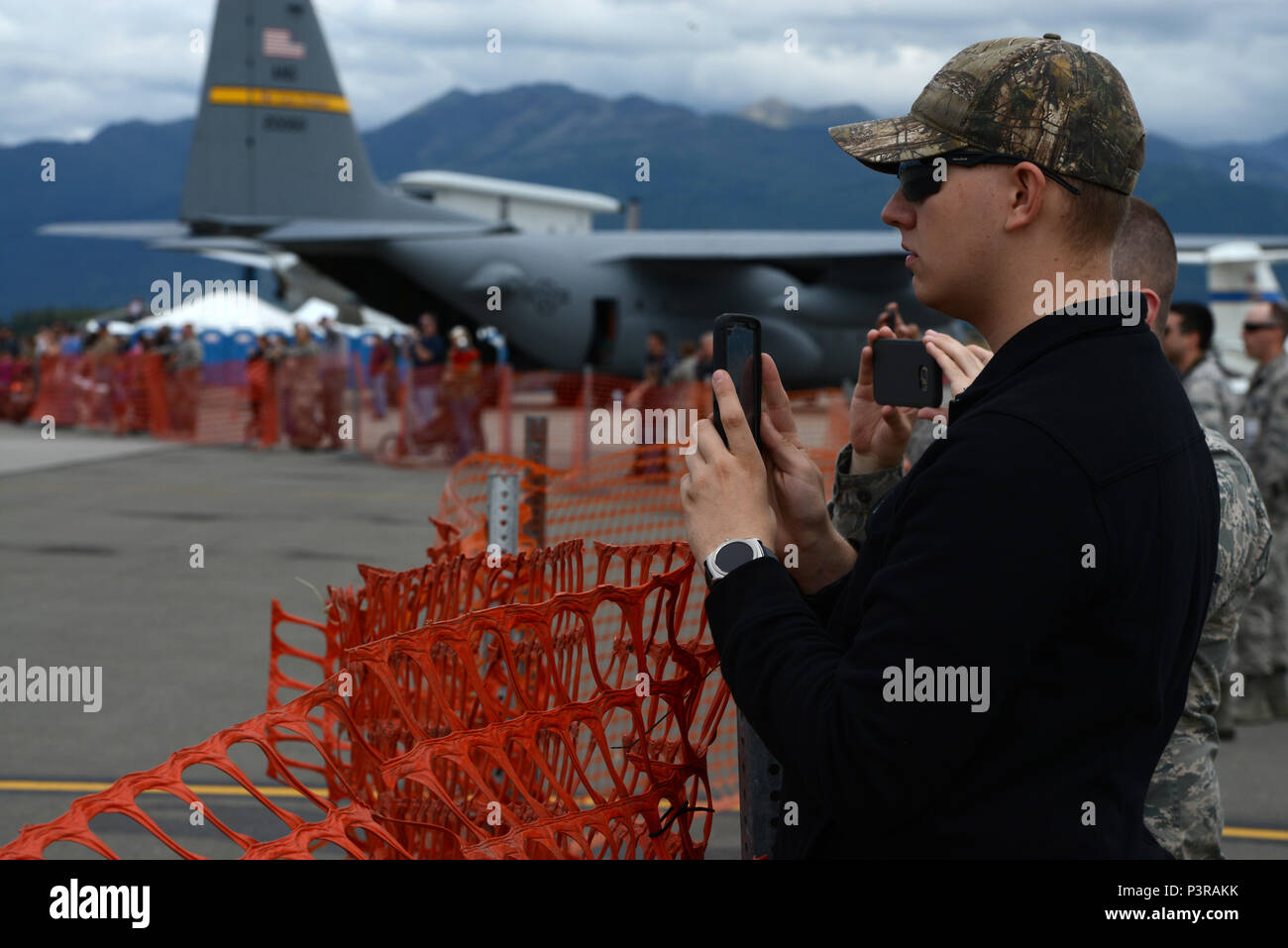 Gregory Decker, a weapons systems coordinator with 3rd Maintenance Group at JBER takes photos of the U.S. Navy Flight Demonstration Squadron, the Blue Angels take-off during Arctic Thunder Special Needs and Family Day, July 29, 2016. JBER will open the doors to the public, showcasing more than 40 key performers and ground acts to include the JBER joint forces, U.S. Air Force F-22, and U.S. Navy Blue Angels demonstrations teams. (U.S Air Force photo by Airman 1st Class Javier Alvarez) Stock Photo