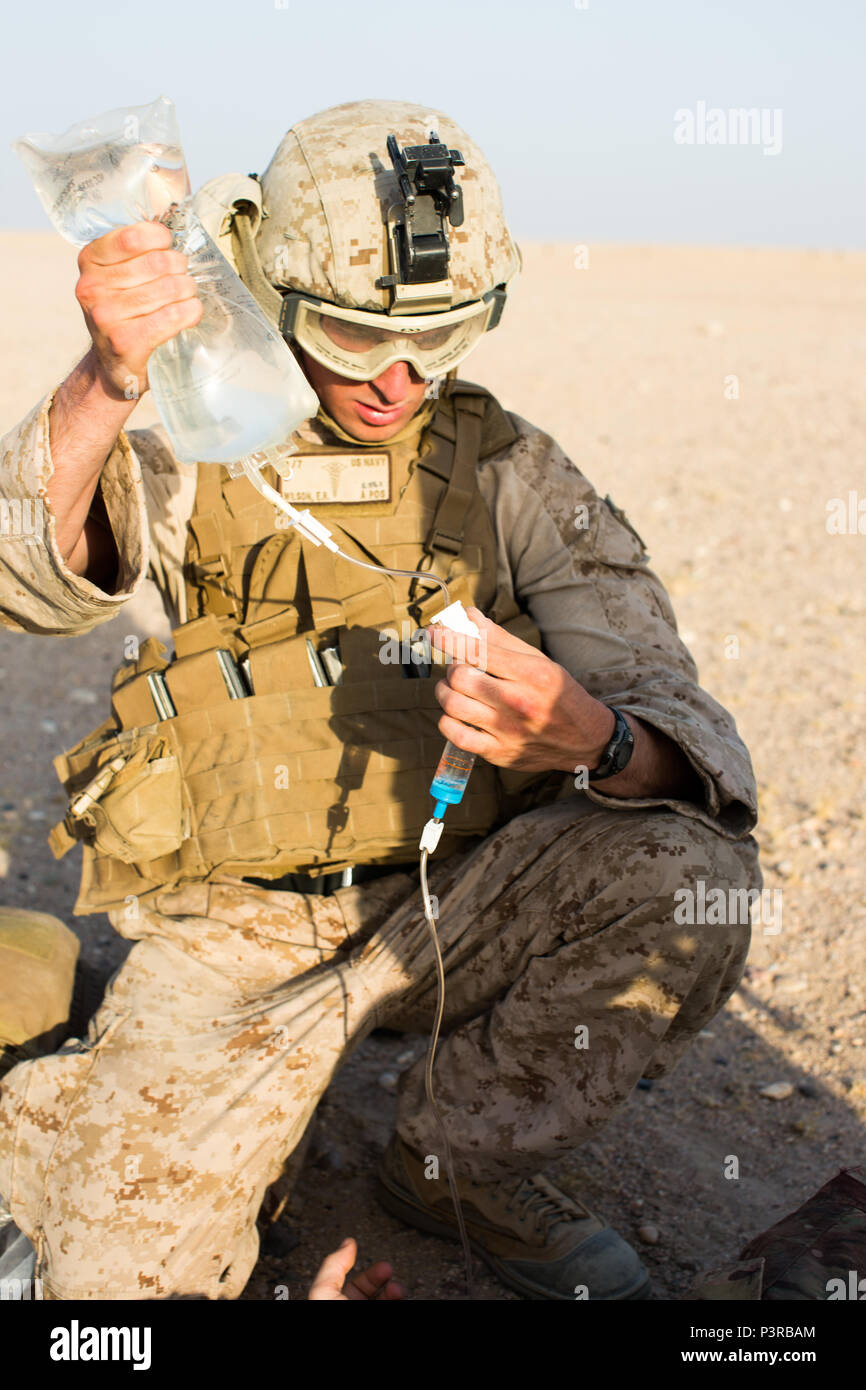 U.S. Navy Hospital Corpsman Third Class Erik Wilson with Special Purpose Marine Air Ground Task Force - Crisis Response - Central Command, prepares an intravenous fluid replacement bag for a stimulated casualty during a Tactical Recovery of Aircraft and Personnel exercise, July 18, 2016. SPMAGTF – CR – CC is a self-sustaining expeditionary unit, designed to provide a broad range of crisis response capabilities throughout the Central Command area of responsibility, using organic aviation, logistical, and ground combat assets, to include TRAP and embassy reinforcement. (U.S. Marine Corps photo b Stock Photo