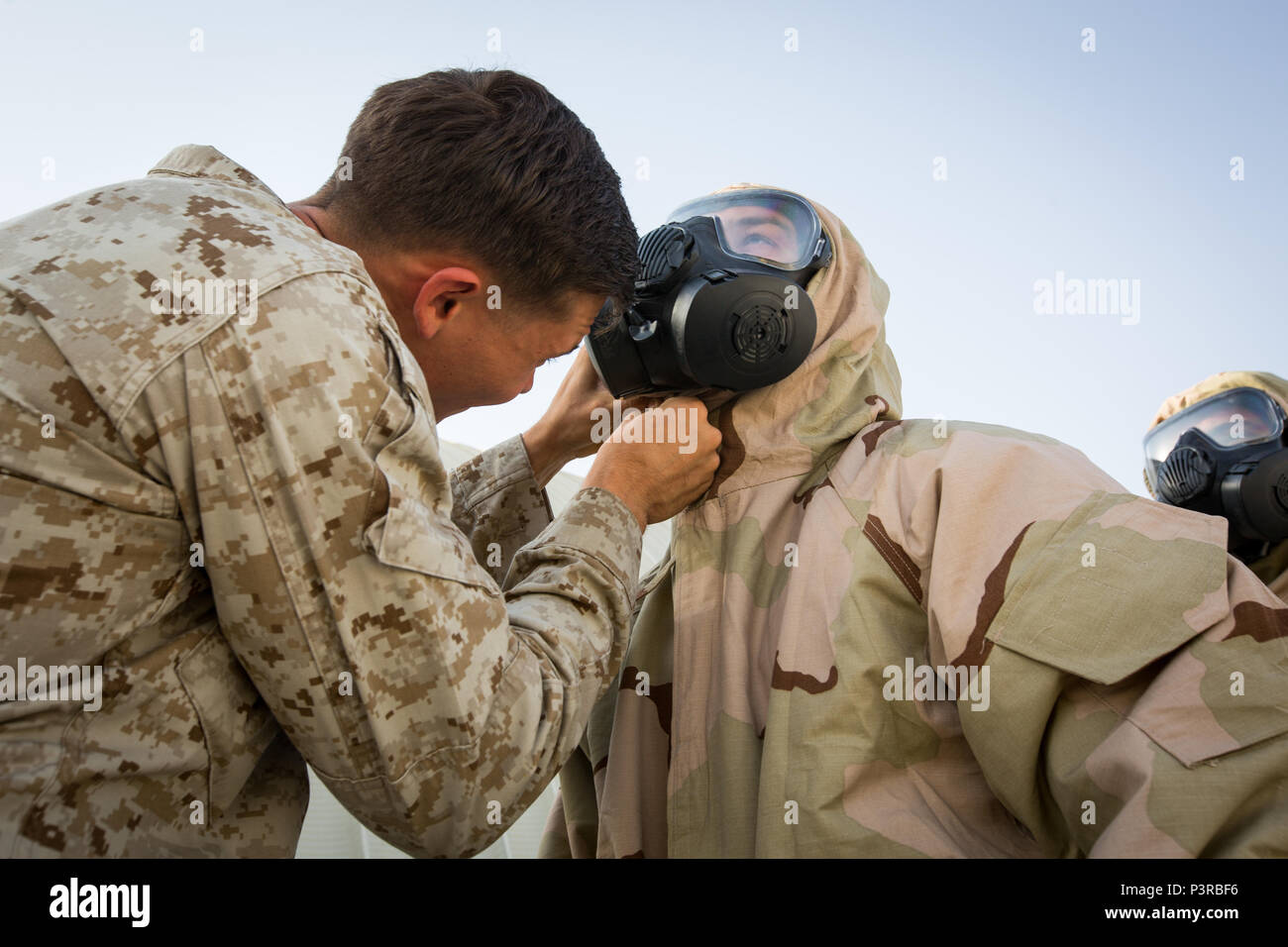U.S. Marine Cpl. Travis Knigge, left, a Chemical, Biological, Radiological and Nuclear Defense specialist with Special Purpose Marine Air-Ground Task Force - Crisis Response - Central Command, inspects a Marine’s gas mask during a Reconnaissance, Surveillance and Decontamination course run by Chemical, Biological, Radiological and Nuclear Defense Marines while forward deployed, July 16, 2016. SPMAGTF-CR-CC is a crisis response unit that has the ability to project combat power throughout the Central Command area of responsibility, using organic aviation, logistical, and ground combat assets. (U Stock Photo