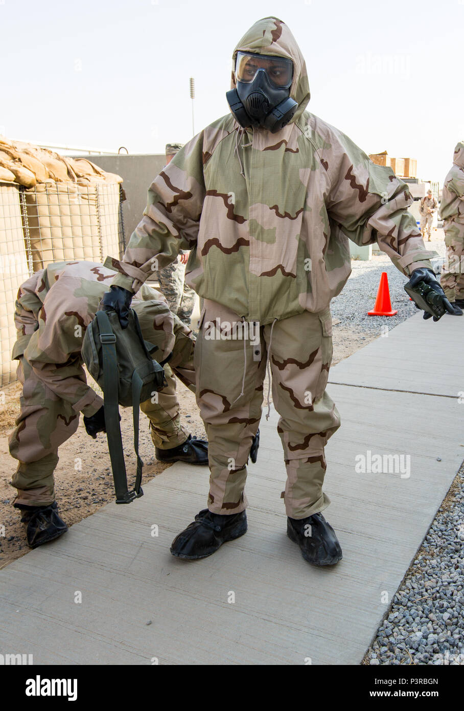 U.S. Marine Lance Cpl. Kory Wormington, a military policeman with 1st Law Enforcement Detachment, Special Purpose Marine Air-Ground Task Force - Crisis Response - Central Command, is assisted with removing his “contaminated” Mission Oriented Protective Posture suit during a Reconnaissance , Surveillance and Decontamination course run by Chemical, Biological, Radiological and Nuclear Defense Marines while forward deployed, July 16, 2016. SPMAGTF-CR-CC is a crisis response unit that has the ability to project combat power throughout the Central Command area of responsibility, using organic aviat Stock Photo