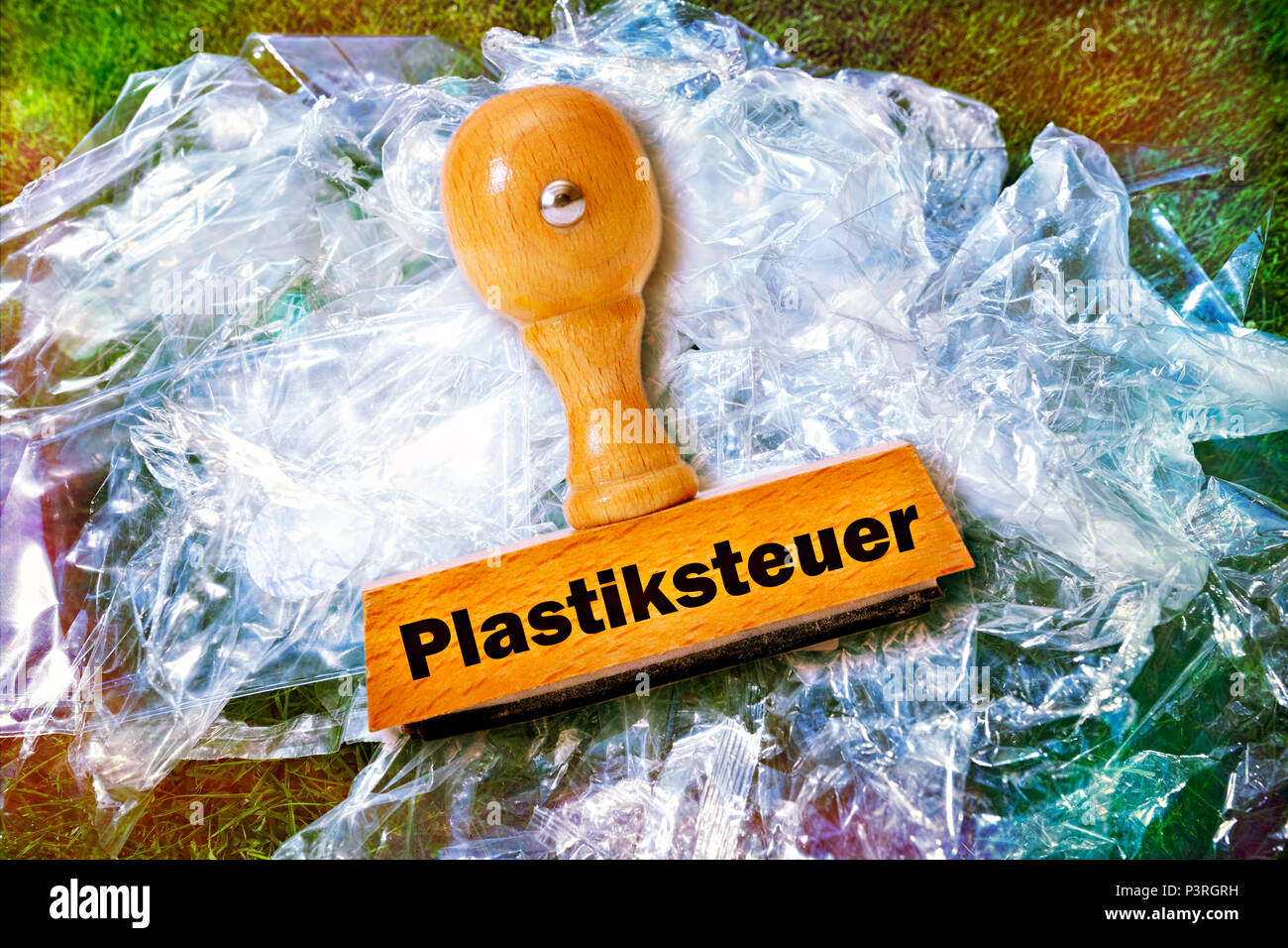 Plastic packaging waste and stamp with the words plastic control, Verpackungsmüll aus Kunststoff und Stempel mit der Aufschrift Plastiksteuer Stock Photo