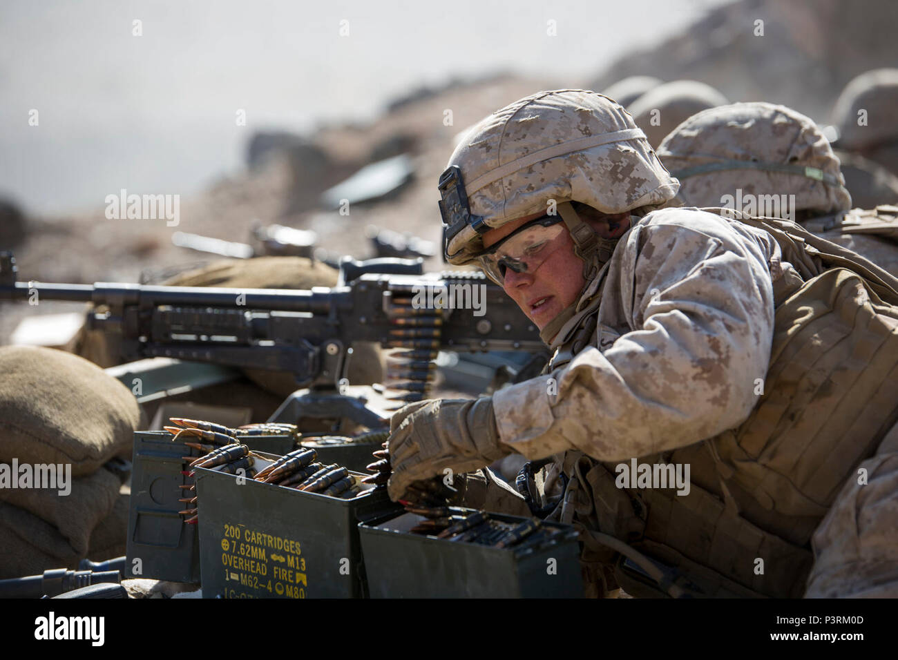 MARINE CORPS AIR GROUND COMBAT CENTER TWENTYNINE PALMS, California – Cpl. Savannah Chase, a machine gunner with Weapons Platoon, Alpha Company, 1st Battalion, 8th Marine Regiment, prepares ammunition for an M240B Machine Gun during a reinforced company assault at Range 400 aboard Marine Corps Air Ground Combat Center Twentynine Palms, California, May 8, 2017. The Marines conducted a company level assault reinforced by machine guns, vehicles, mortars and snipers as part of Integrated Training Exericse 3-17. ITX is a training evolution conducted five times a year to enhance the lethality and co- Stock Photo