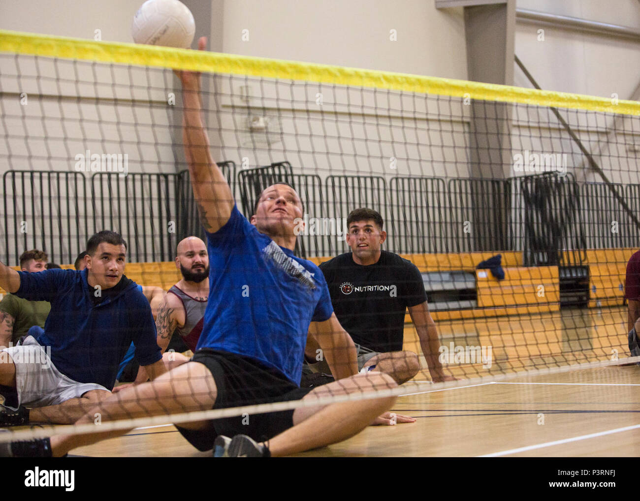 U.S. Marine Corps Gunnery Sgt. Dorian Gardner attempts to block the ball during sitting volleyball drills during a 2017 DoD Warrior Games training camp at Marine Corps Base Camp Pendleton, Calif., May 7, 2017. Gardner, a native of Rialto, Calif., is a member of the 2017 DoD Warrior Games Team Marine Corps. The DoD Warrior Games is an adaptive sports competition for wounded, ill and injured service members and veterans. Stock Photo