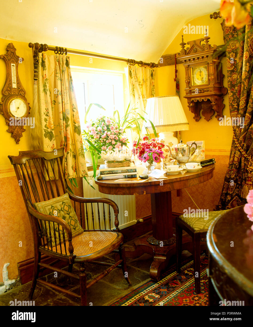 Antique chair and table with tea set in small cottage dining room with barometer and clock on