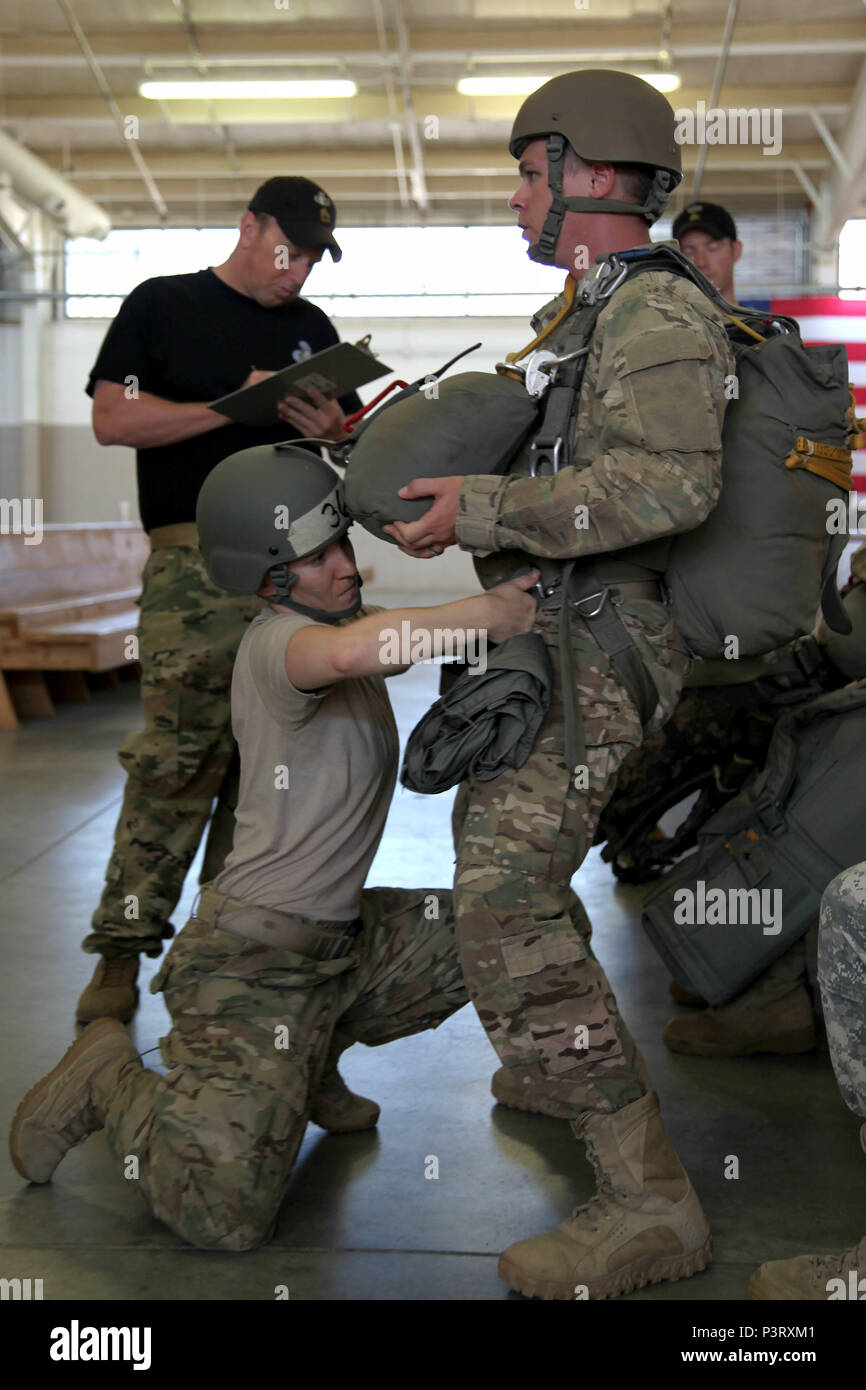A student of the U.S. Army Special Operations Command static line jumpmaster course inspects a Paratrooper’s equipment during the jumpmaster practical inspection exam, July 20. Of the 40 Paratroopers who began the course, led by 4th Military Information Support Group jumpmasters, only 23 completed it successfully. The course concentrates on the actions taken on the ground and in the air to safely exit Paratroopers from a number of different aircraft. (U.S. Army photo by Capt. Stephen Von Jett/Released) Stock Photo