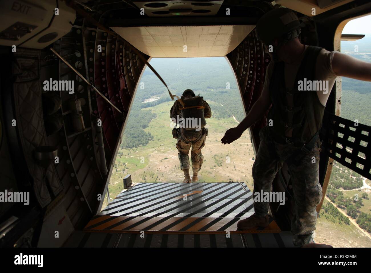 A U.S. Army Special Operations Command Paratrooper exits from the ramp of a Casa 212 aircraft after receiving the command of “Go!” from a student (right) during the culminating event of the course, July 27. Of the 40 Paratroopers who began the course, led by 4th Military Information Support Group jumpmasters, only 23 completed it successfully. The course concentrates on the actions taken on the ground and in the air to safely exit Paratroopers from a number of different aircraft. (U.S. Army photo by Staff Sgt. Kissta DiGregorio/Released) Stock Photo