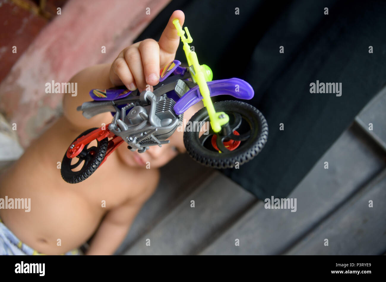 RECIFE, PE - 10.10.2015: FAVELA DO COQUE - Criança brinca com motocicleta de brinquedo, na comunidade carente do Coque, em Recife (PE). (Foto: Diego Herculano / Fotoarena) Stock Photo