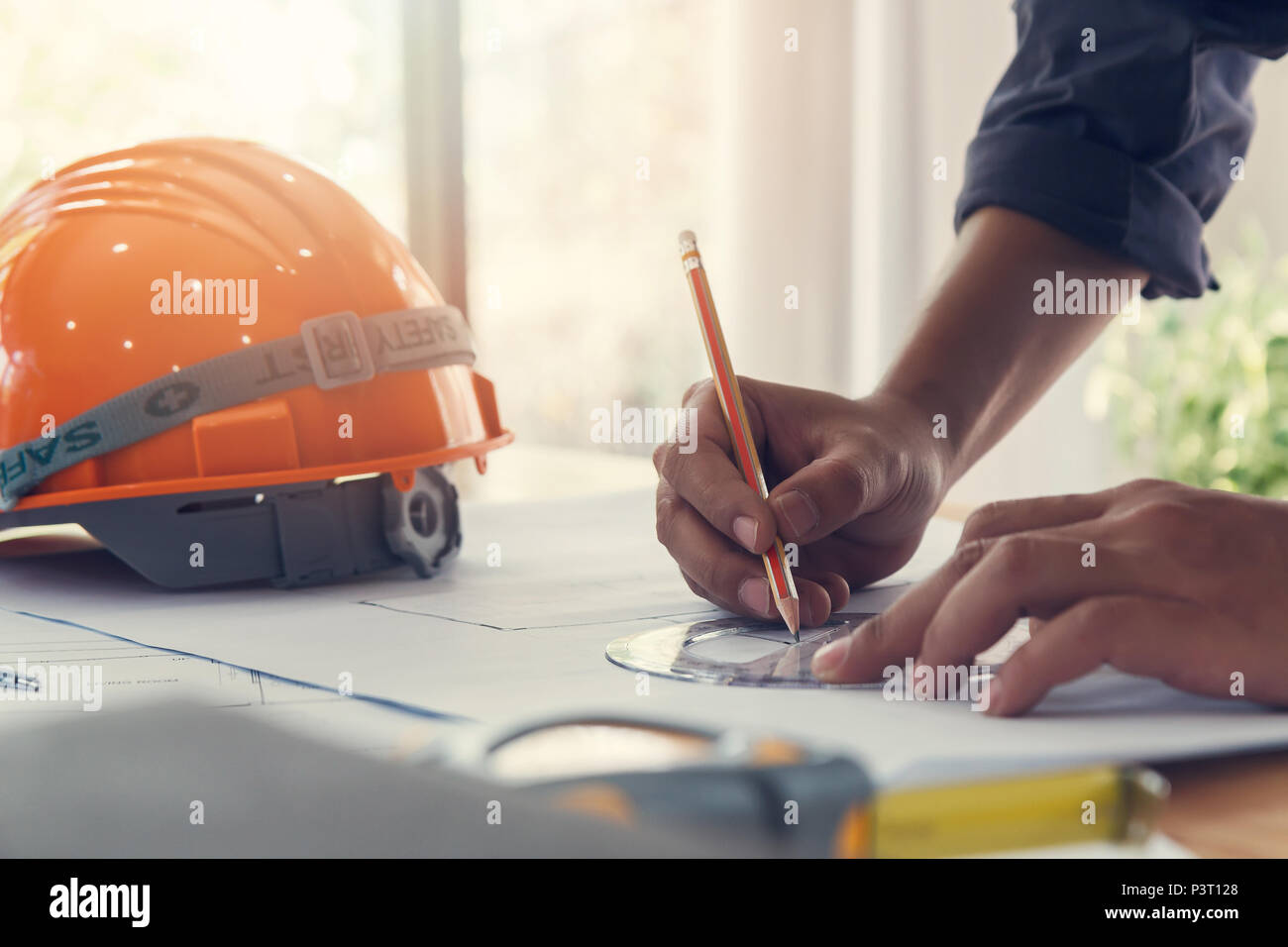 Architect or engineer using pencil and protractor working on blueprint, architectural concept Stock Photo