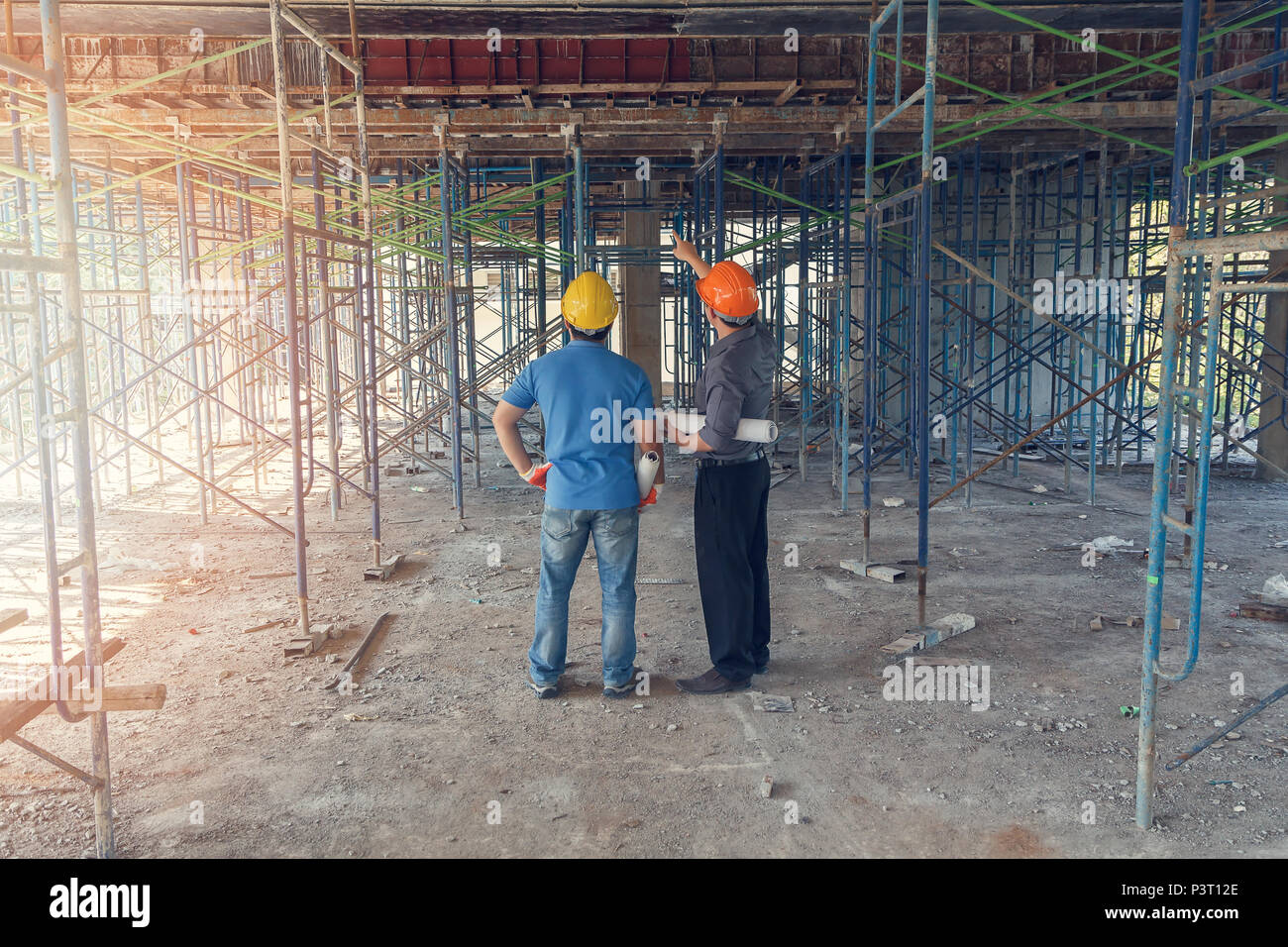 Engineer discussing with foreman about project in building construction site Stock Photo