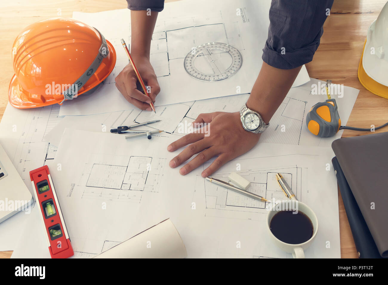 Architect or engineer using pencil working on blueprint, architectural concept Stock Photo