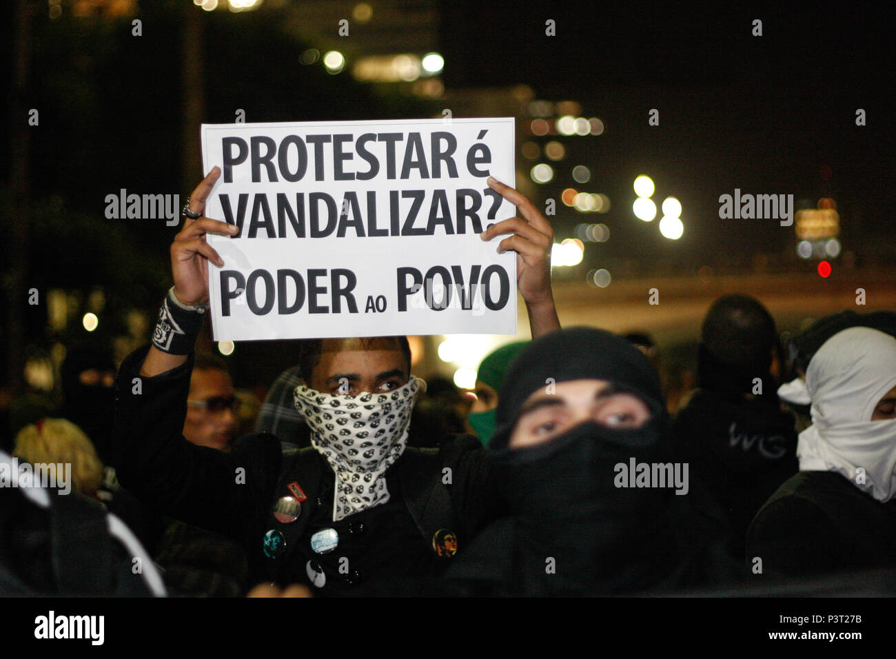 SÃO PAULO, SP - 01.08.2013: CARTAZ EM MANIFESTAÇÃO SP -  Manifestante mascarado segurando uma placa com a frase 'Protestar é vandalizar? Poder ao povo'. (Foto: Luis Blanco / Fotoarena) Stock Photo