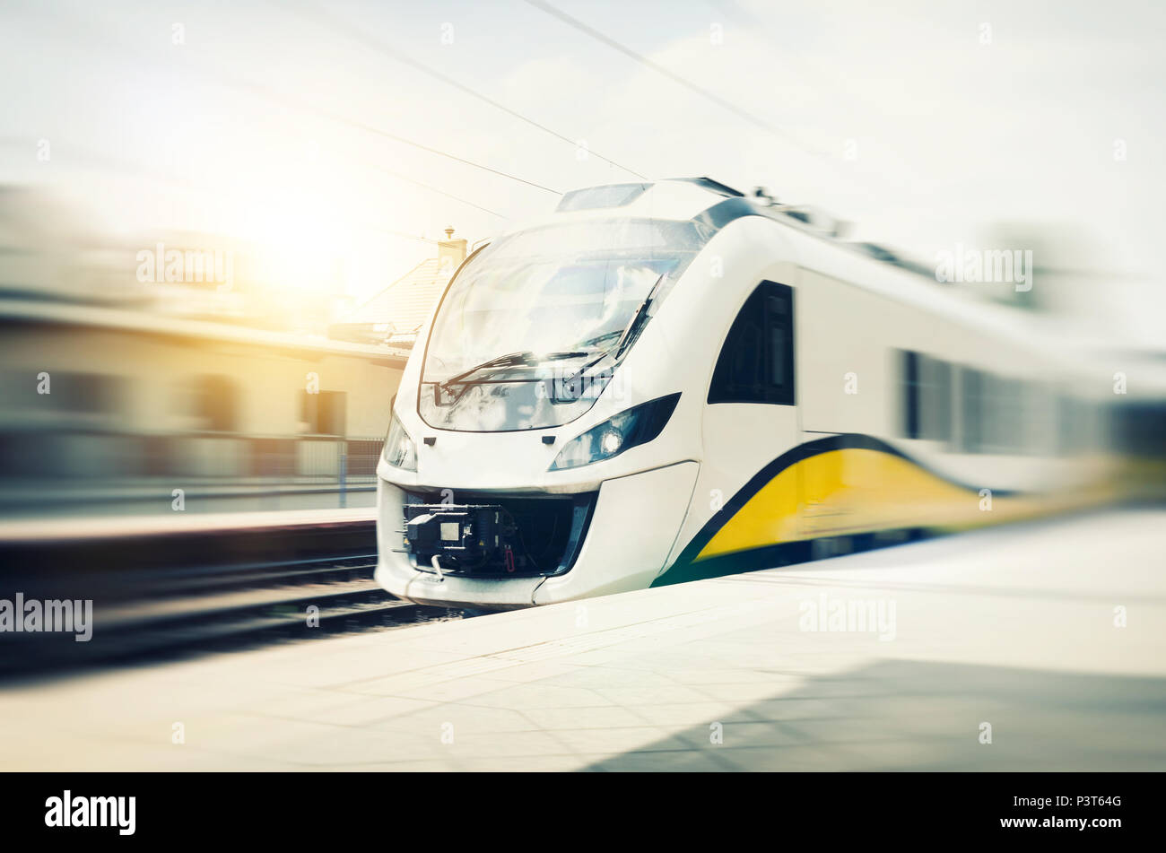 High speed train in motion at the railway station. Landscape with passenger train on railroad Stock Photo