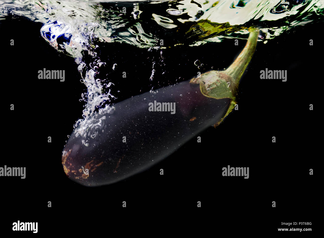 Vegetables (eggplant) Solanum melongena fall into the water. Splash of