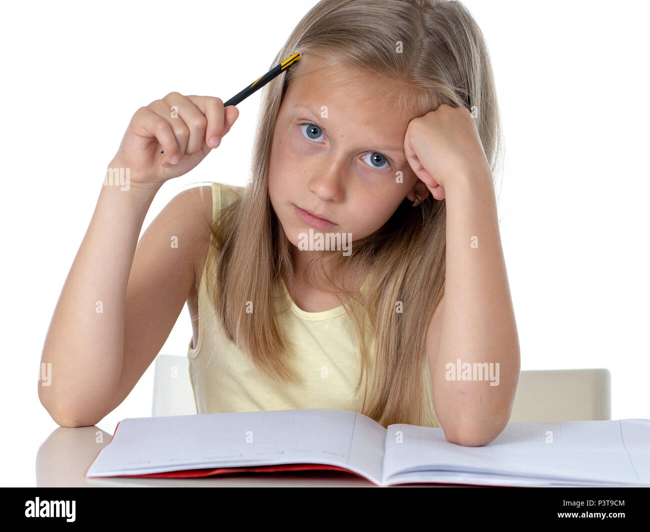 education, elementary school, childhood and emotions concept sad or bored little student girl studying looking frustrated with learning problems on wh Stock Photo