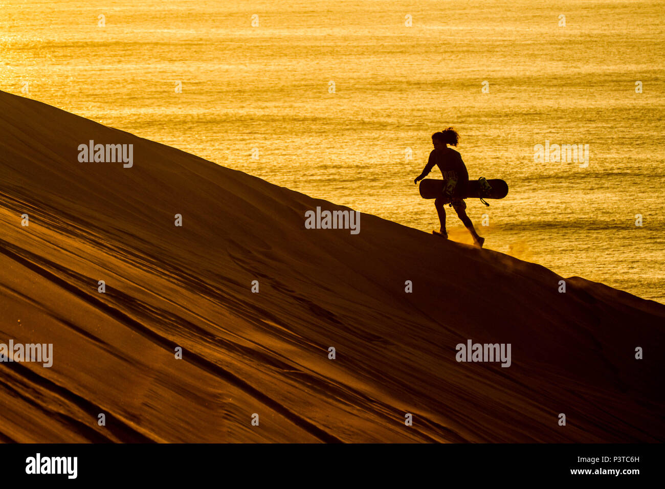 IQUIQUE, CHILE - 15.11.2015: DESERTO DO ATACAMA - Silhueta de sandboarder caminhando ao por do sol em Cerro Dragón, uma duna situada junto à cidade de Iquique, no Deserto do Atacama. (Foto: Ricardo Ribas / Fotoarena) Stock Photo