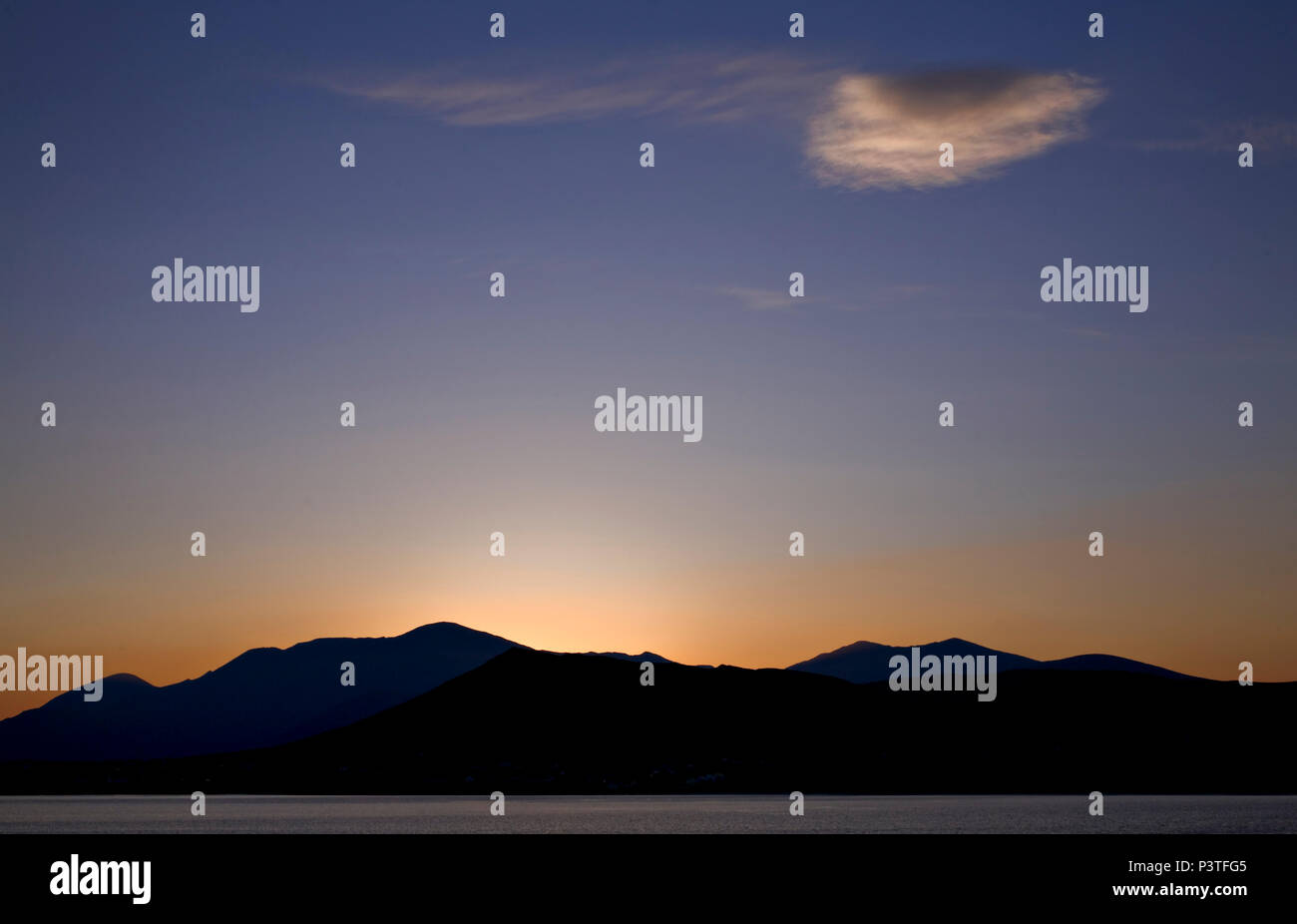 Single cloud over mountains and sea at sunrise on the west coast of Ireland at Dingle Stock Photo