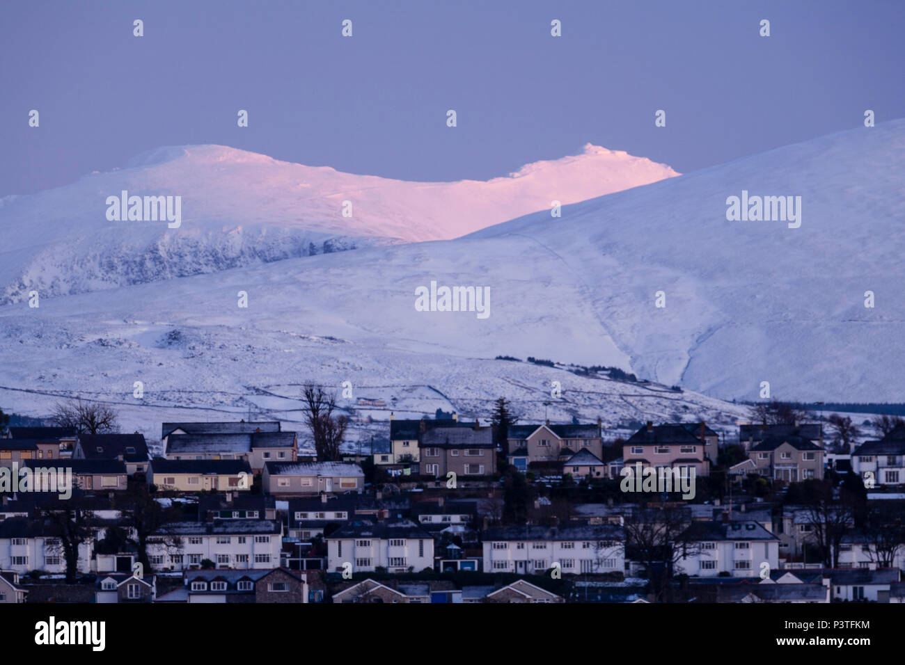 Snow covered mountains behind houses in Snowdonia, North Wales in winter Stock Photo