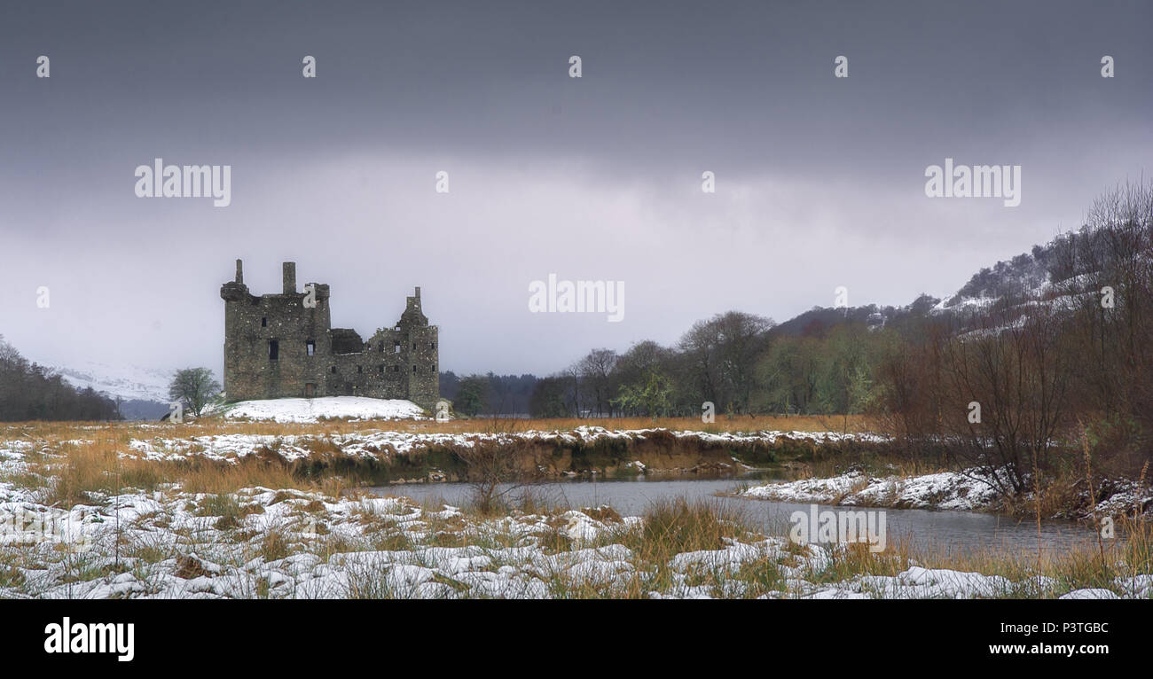 Ruins of a Scottish castle on the bank of a winter river. Stock Photo
