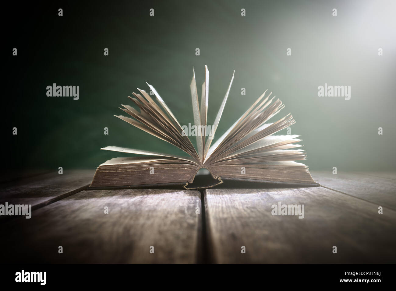 Old book or open Holy Bible on a table with spot light Stock Photo