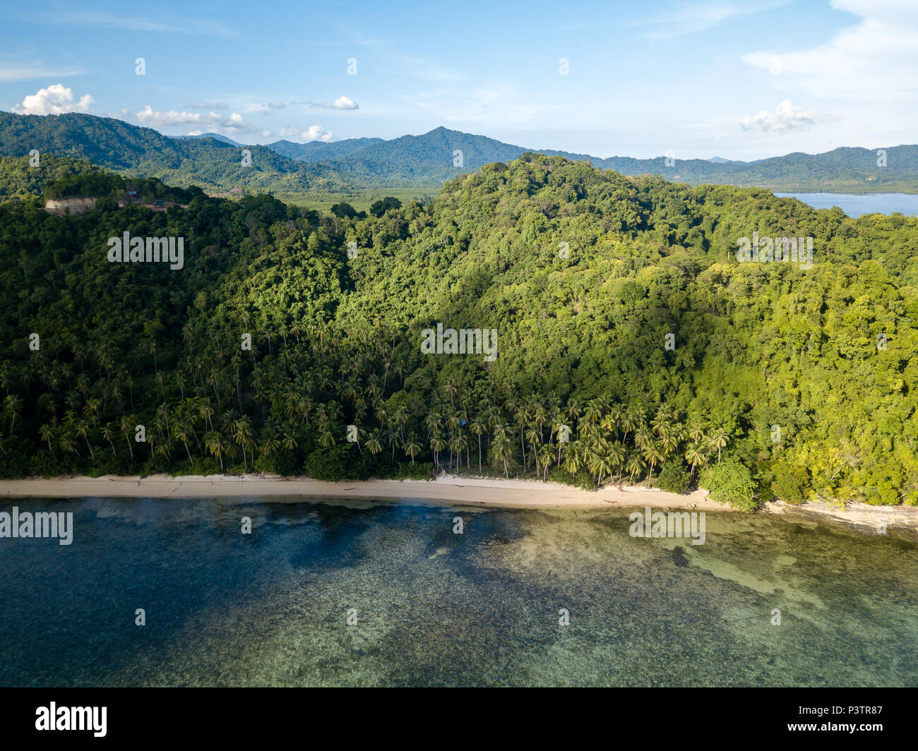 Aerial drone view of a beautiful tropical bay with reef, sandy beach and jungle scenery Stock Photo