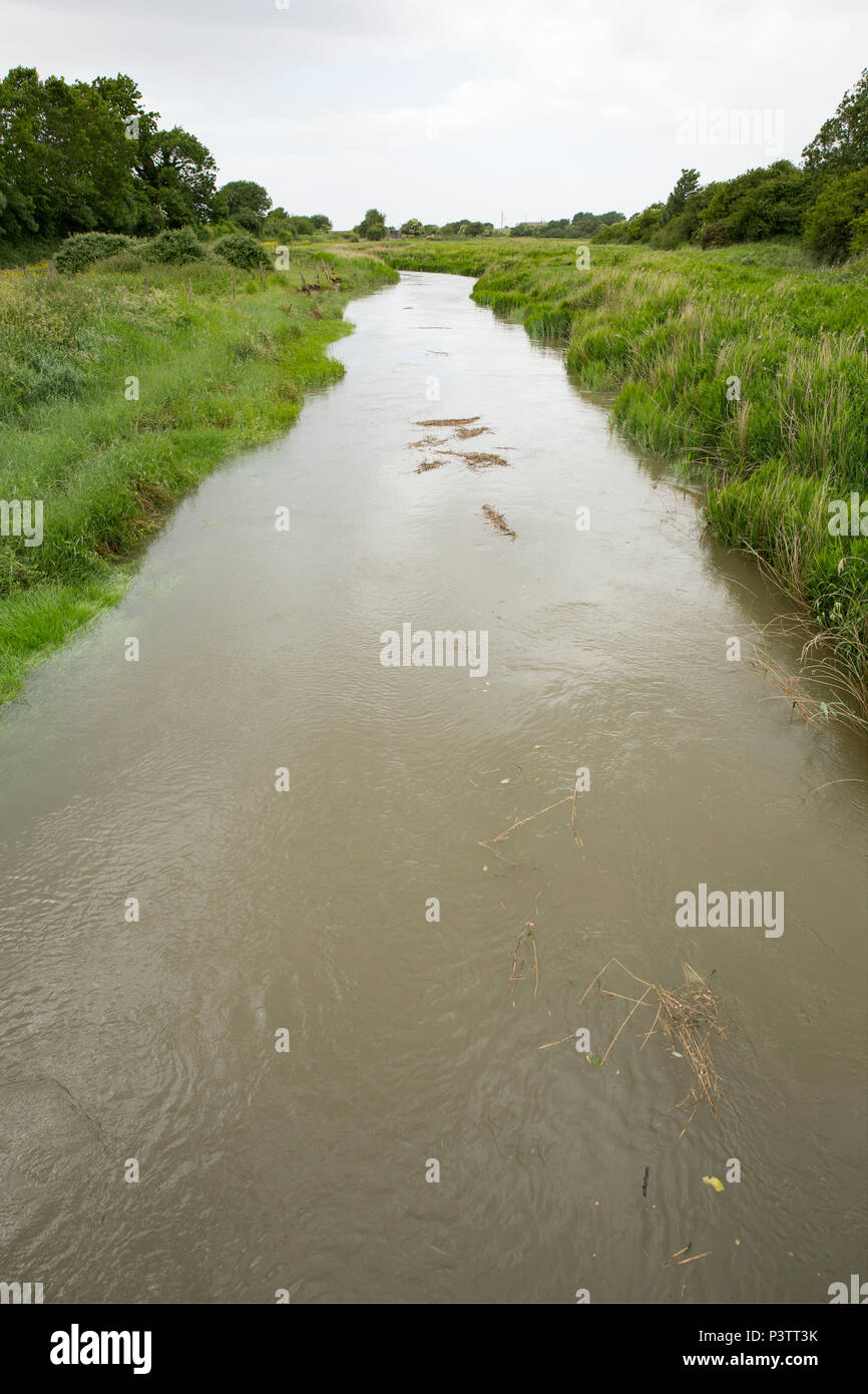 A tidal section of the River Keer with the tide starting to ebb near Carnforth in Lancashire. The River Keer flows into Morecambe Bay. Carnforth Lanca Stock Photo